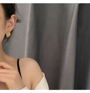 Close-up of geometric crystal stud earrings shown on model with gold-tone base
