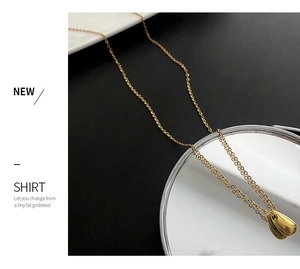Close-up of polished gold teardrop pendant on thin O-chain with mirror finish