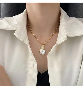 Détail macro du pendentif plume élégant avec nacre blanche sur une chaîne à billes