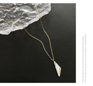 Détail macro du pendentif géométrique avec nacre et zircon sur une chaîne dorée