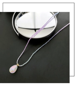 Detailansicht eines Wassertropfen-Opal-Anhängers an lila-blauer Perlenkette