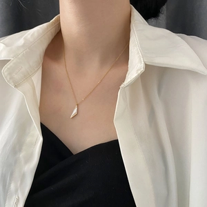 Collier minimaliste en titane doré avec un pendentif géométrique blanc sur chaîne fine
