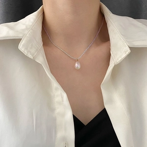 Elegante Perlenhalskette mit einem perlmuttfarbenen Wassertropfen-Anhänger an einem Model