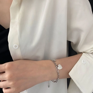 Bracciale a catena trombone in acciaio al titanio con pendente a cuore su modella