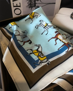 Detailaufnahme des Seidenschals mit Reitsport-Pferdedruck in Himmelblau und Braun