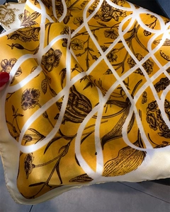 Détail d'un foulard en soie jaune avec imprimé floral noir et motif à carreaux blancs