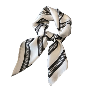 Elegant black and white geometric silk scarf tied in a stylish knot on a white background