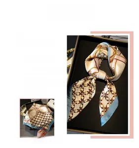 Detail of silk-like square scarf featuring classic golden chain and red-blue link patterns