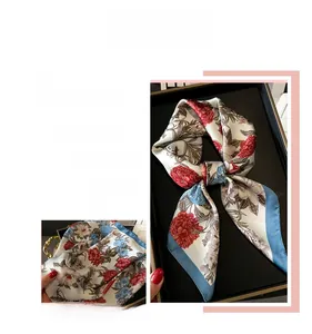 Detailed view of floral silk scarf featuring elegant blue borders and printed petals