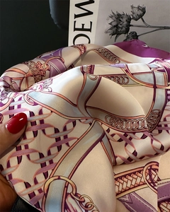 Close-up of elegant chain buckle print silk scarf with luxury satin texture and purple tones