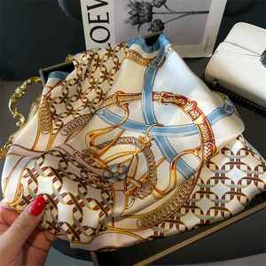 Close-up of elegant chain print silk scarf with vintage gold links and blue accents