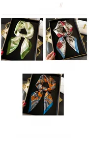 Detailed view of silk-like neck scarves with floral and paisley patterns in gift trays