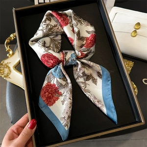 Elegant floral silk scarf with lotus print in red and blue, styled in a luxury gift box