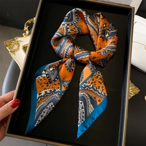 Elegant paisley silk scarf in vibrant orange and navy blue, presented in a premium gift box