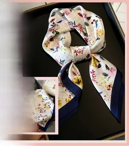 Close-up of floral silk scarf with elegant grey grid pattern and navy blue border