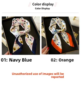 Detail of floral silk scarves in navy blue and orange trim on display tray