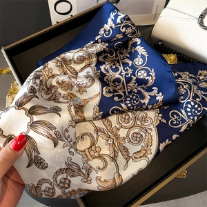 Detail of silk scarf showing Baroque floral patterns and glossy satin texture in blue