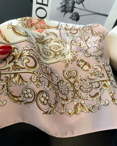 Detailed texture of floral satin neckerchief with golden baroque patterns and soft pink silk