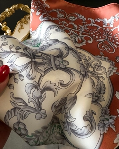 Detail of baroque floral silk scarf showing glossy texture and elegant printed pattern