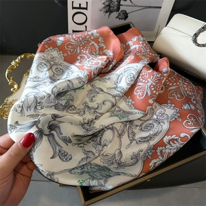 Close-up of floral silk-feel scarf with baroque patterns in elegant gift box setup