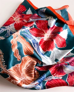 Close-up of a floral satin silk scarf showing hibiscus patterns and silky texture