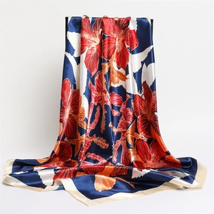 Detail of red floral print on navy blue satin scarf with creamy border
