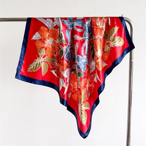 Detail of red floral satin scarf showing silky texture and blue contrast hem