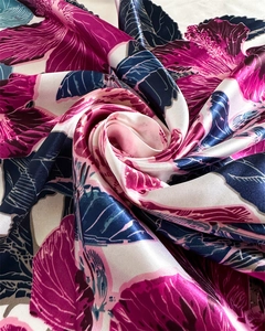 Macro detail of silk-like satin scarf featuring vibrant floral prints and smooth texture