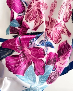 Close-up of satin scarf fabric with hibiscus flower prints and silky texture
