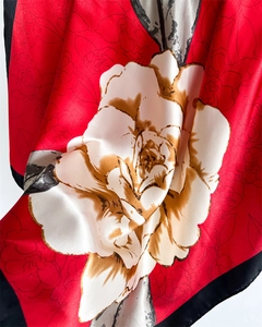 Macro detail of red satin floral scarf showing smooth texture and large camellia print