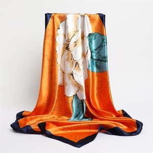 Detailed texture of satin square scarf featuring orange camellia floral print and blue borders