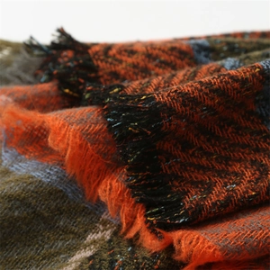 Détail des franges de l'écharpe en tricot d'automne avec motif à carreaux orange et brun