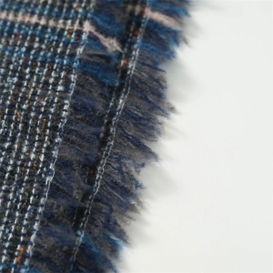 Détail macro du tissu à carreaux avec fils colorés et bordure à franges