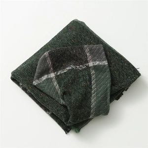 Détails du tissage à chevrons et franges sur ce poncho à capuche à carreaux vert foncé