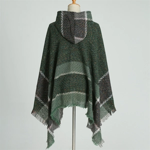 Détail d'un poncho à capuche à carreaux avec tricot chevrons vert et ourlet à franges