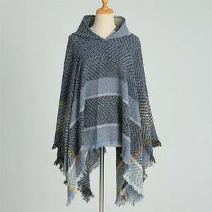Détail d'un poncho à capuche bleu-gris avec motifs à chevrons et finitions à franges douces