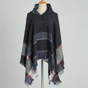 Détail d'un poncho à capuche à carreaux bleu et gris avec franges et texture tricotée