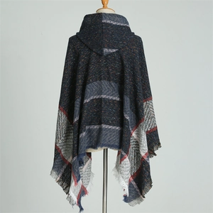 Détail d'un poncho à capuche à carreaux bleus avec franges et texture type cachemire