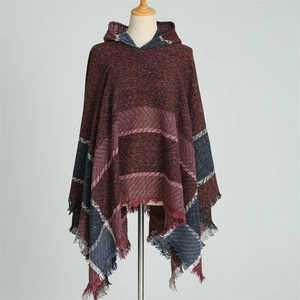 Détail du poncho à capuche avec motif à carreaux et finitions à franges douces
