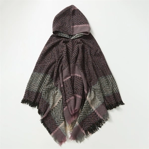 Détail du tricot à chevrons violets avec de longues franges sur le poncho à capuche