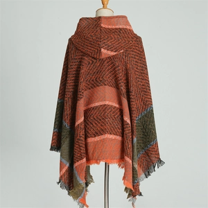 Détail d'un poncho à capuche en tricot avec rayures géométriques et bordures à franges