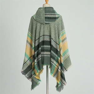 Detail of the hooded plaid poncho featuring green and mustard checkers with fringe edges