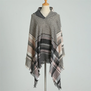 Detail of hooded plaid poncho featuring grey and pink check patterns with fringed edges