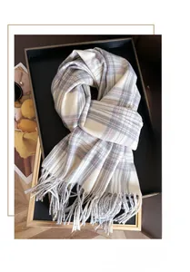 Detail of plaid scarf with fringe in beige and pink on a stylish display tray