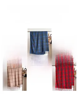 Detail of plaid scarves with fringe in blue, brown and red tartan patterns