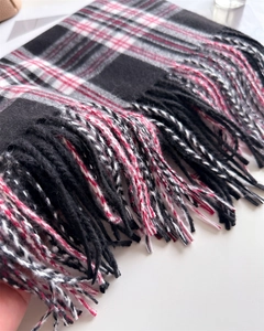 Detail shot of the red plaid scarf showing soft fabric texture and fringe tassels