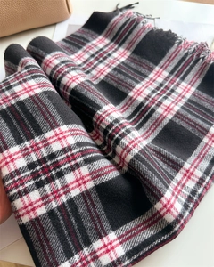 Close-up of red and black plaid scarf texture with soft fringe details
