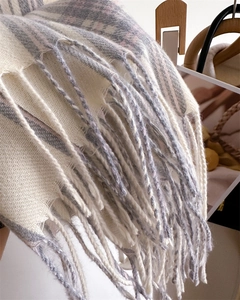 Detailed macro view of the soft plaid cashmere-like fabric and long tassel textures