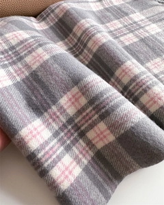 Close-up of soft plaid scarf fabric with pink, grey and white Scottish check pattern