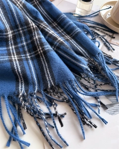Close-up of blue, black and white plaid scarf with delicate fringe details and soft texture
